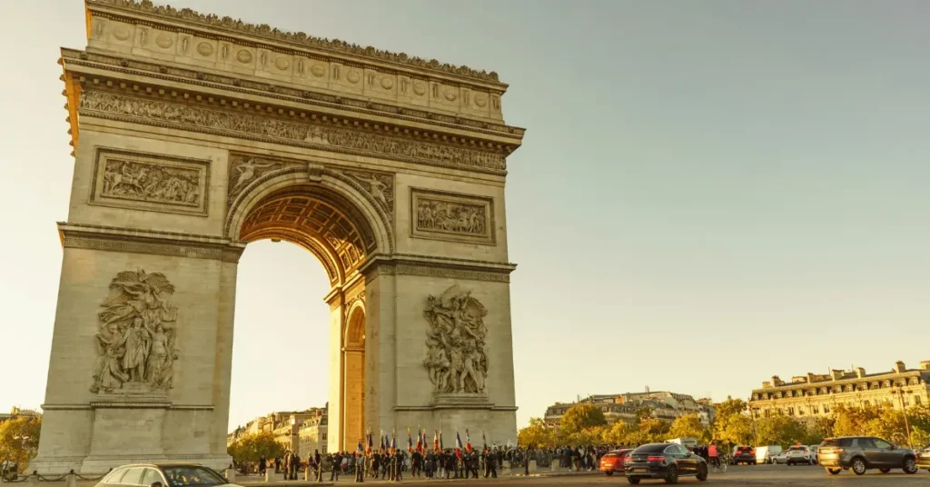 Wide view of the Arc de Triomphe with the Champs-Élysées stretching behind it.