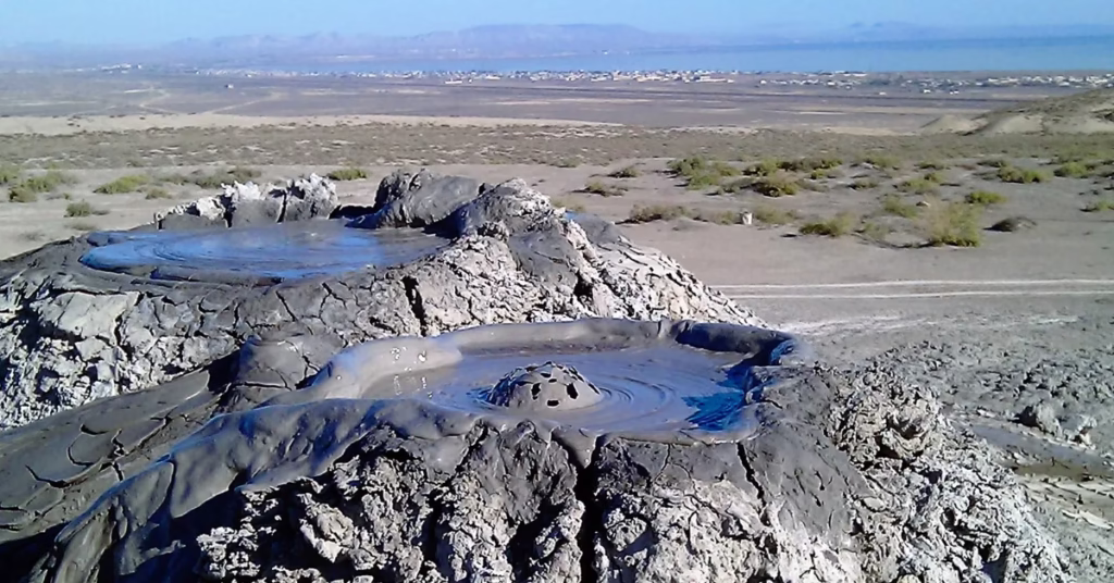 Explorer visiting bubbling mud volcanoes during Baku adventure travel