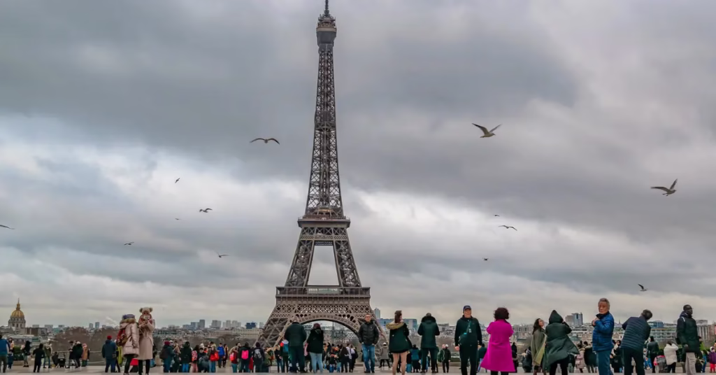 Eiffel Tower sparkling during its night show with visitors watching from Trocadéro
