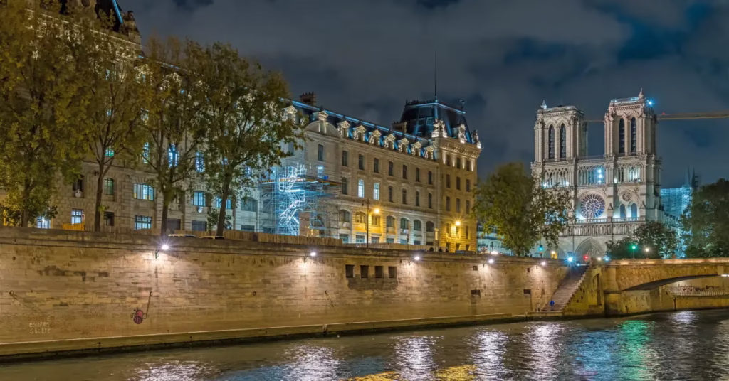 Notre-Dame Cathedral glowing at night with peaceful riverside reflections