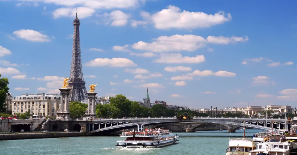Seine River night cruise passing illuminated Paris landmarks.