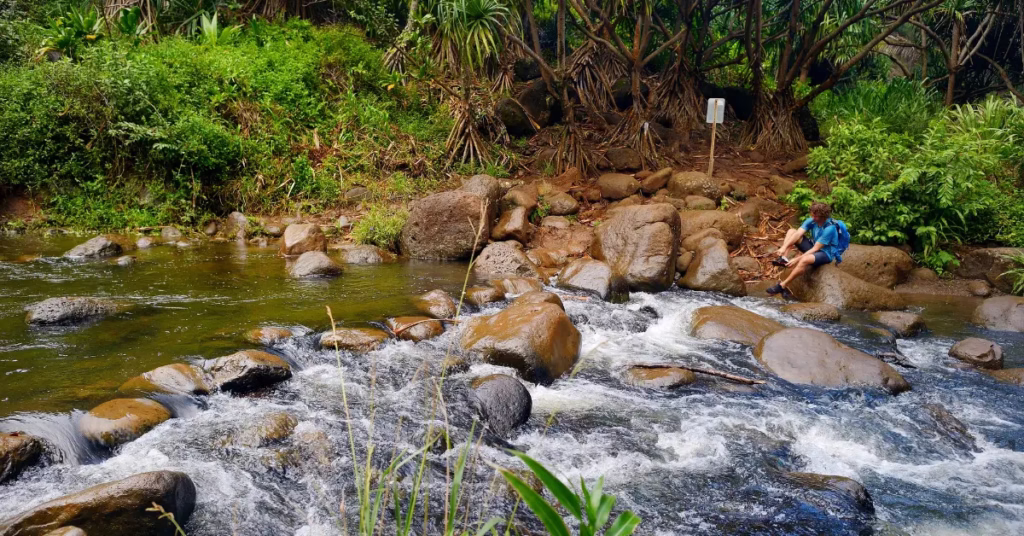 Trekker navigating river during Hiking