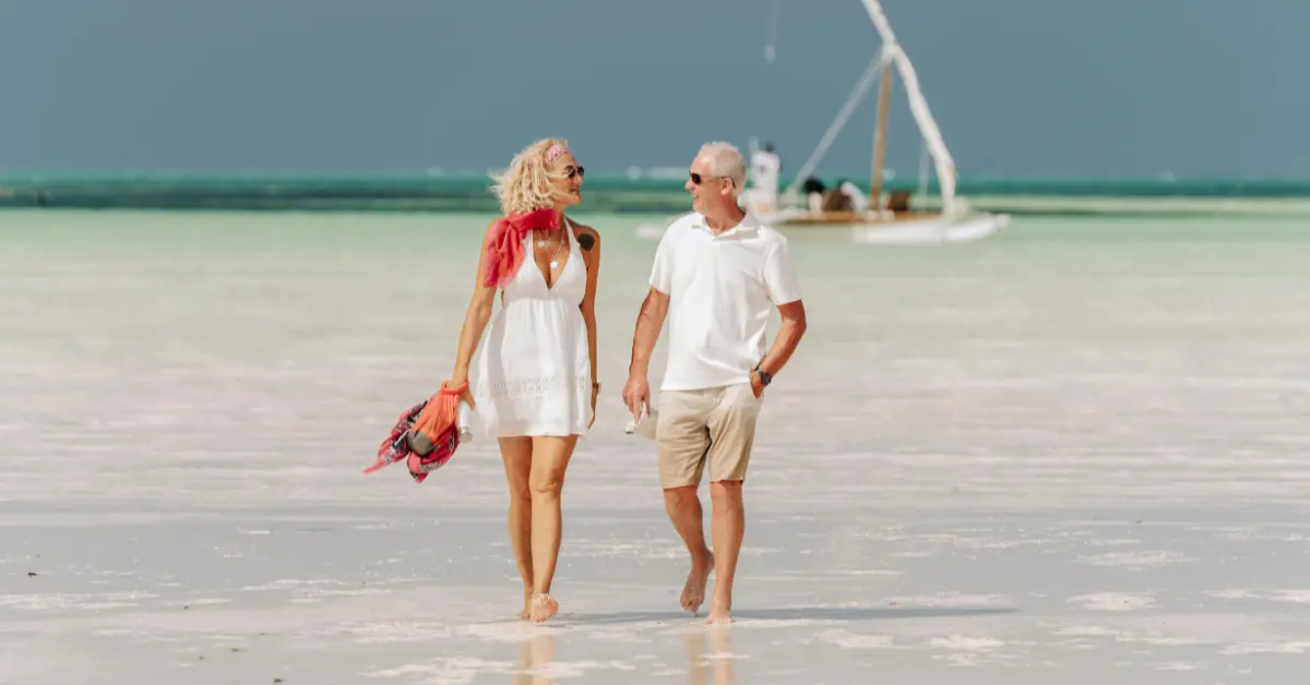Couple walking on a romantic tropical beach at sunset